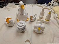 Photo showing full lot of ceramic duck-themed kitchen and decor items on white surface
