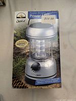 Box packaging for Innovage Outdoor 12-LED Power Lantern showing product image, price tag, and key features including dual power capability and LED lighting.