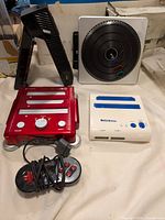 Overview photo showing Retrobit Retro Duo, Hyperkin Retron 3, DJ Hero turntable, Xbox One accessory, and SNES style controller