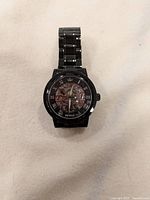 Front view of black Sewor mechanical skeleton watch showing skeleton dial with visible gears and Roman numerals.