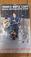 Cover of 1963-64 Toronto Maple Leafs information book showing two players on ice, one in blue Leafs uniform and one in yellow opponent uniform, includes Stanley Cup records.