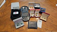 Photo of all items in the lot showing leather wallet, nail grooming kit, multiple pairs of cufflinks and tie clips in boxes.