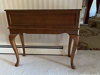 Front view of wooden planter box chest showing rectangular shape, decorative molding, and curved legs.