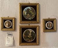 Four ceramic framed wall art pieces arranged on a wall showing vintage scenes and landscapes. Gold ornate frames with black velvet backing.