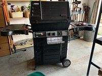 Full view of the Fiesta Classic 400 propane BBQ with two side tables and wheels in garage setting.