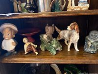 Shelf with vintage collectible figurines including Speedy Alka Seltzer doll bank, vintage dog, green car figurine, and others