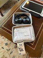 Sony noise cancelling headphones inside white zip case with instruction manual and maxsold tag visible.