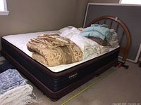 Full view of mattress, box spring, frame and headboard with bedding