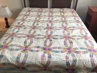 Full view of queen size wedding ring quilt on bed showing multicolored circular interlocking pattern