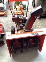 Front view showing serrated auger blades inside red housing