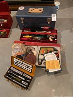 Full lot overview showing tool boxes, drill case, ratchet set, sanding discs on floor