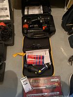 Mastercraft socket wrench set in case, with a Black & Decker cordless drill in case and manuals on floor