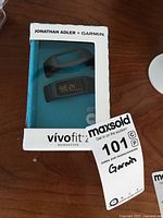 Garmin Vivofit 2 fitness tracker watch in original box showing product and branding including Jonathan Adler collaboration.