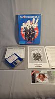 Photo of the original Ghostbusters II game box, Player's Guide, two 3.5-inch floppy disks, and additional papers.