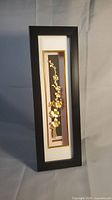 Front view of entire shadow box framed gold flower branch sculpture.
