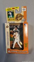 Front view of sealed packaging showing Cal Ripken Action Flats figure and exclusive baseball card inside. Baltimore Orioles orange theme with MLB logo visible.