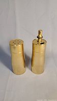 Full view of the Italian brass salt shaker and peppermill side by side showing design and shape