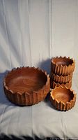 Full set of one large serving bowl and four smaller salad bowls hand carved from mahogany wood with flower-shaped edges.
