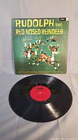 Front view of the album cover and vinyl record showing the vintage Rudolph the Red Nosed Reindeer illustration and the vinyl disc.