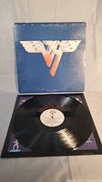 Photo showing the vinyl record on display with album cover in background. The cover is blue with Van Halen logo.