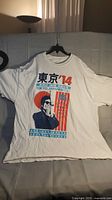 Full view of white Bob Dylan 2014 tour T-shirt laid flat on a surface.