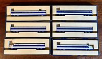 Six Shinkansen model train cars arranged in individual compartments in a box.