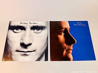 Both Phil Collins vinyl LP album covers shown front by front, Face Value on left black and white face close-up, Hello I Must Be Going on right profile blue background photo.