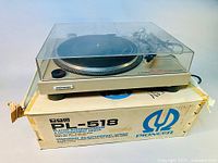 Front view of turntable with closed dust cover on original box