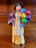 Front view of the Royal Doulton Balloon Lady figurine showing the detailed facial features, colorful balloons, and clothing.