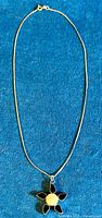 Full view of the pendant necklace laid flat showing the chain and pendant.