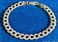 Vintage 925 sterling silver thick link bracelet photographed on a blue cloth background, showing large polished links and lobster claw clasp.