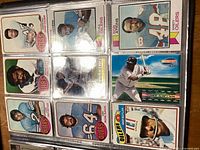 Image showing 12 baseball cards in plastic sleeves, mainly Topps cards from the 1980s, featuring players from Oilers and Mariners among others.
