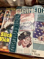 Photo of 1943 Steagles game day official program alongside a Michael Vick sports guide and other football memorabilia.