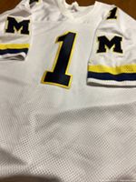 Front view of the white sports jersey with number 1 prominently displayed and M logos on sleeves.