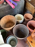 Various pots including terracotta, a wooden bushel basket and small green pot grouped together