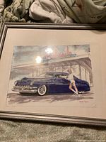 Framed watercolor painting showing classic blue car and woman near a drive-in restaurant, full view