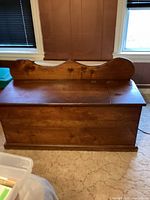 Front view of oak wood Blakey chest showing carved decorative backboard and smooth top surface.