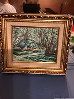 Full frontal shot of framed landscape art print showing the entire 14x12 wood frame with ornate gold decoration and visible natural tree scene in the print.