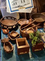 Photo showing the wooden salad bowl with wooden utensils, wooden duck figurine, small wooden dishes, drawer boxes, and part of the wooden lazy Susan.