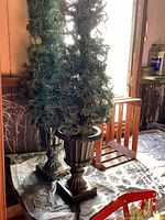 Wooden decorative sled standing near window with pine branch and berries arrangement visible
