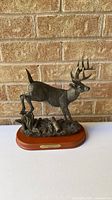 Full view of deer sculpture on wood base