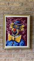 full view of framed clown needlepoint on wall