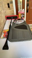 All items on table: floor mats, snow broom, emergency hammer package, Rain-X jug