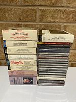 Full lot showing two stacks of CDs including box sets and jewel cases