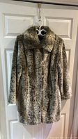 Full front view of gray faux fur coat on hanger