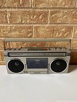 Front view showing entire boombox, speakers, cassette door, handle and antenna