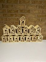 All 14 wooden birdhouse ornaments arranged in rows showing overall quantity and designs