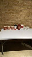 Row of eight Tim Hortons drinkware items on table