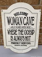 Front view of Woman Cave sign showing full text and design