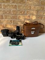 Group shot of all items: camera with lens, zoom lens, two flashes, cases, manual